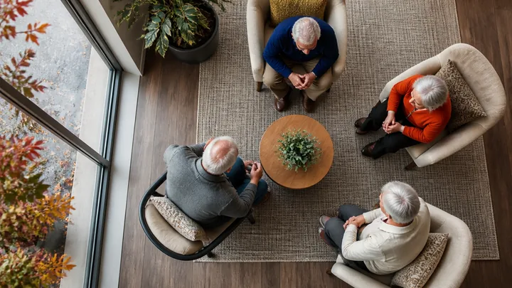 Overhead view of four residents seated around a coffee table