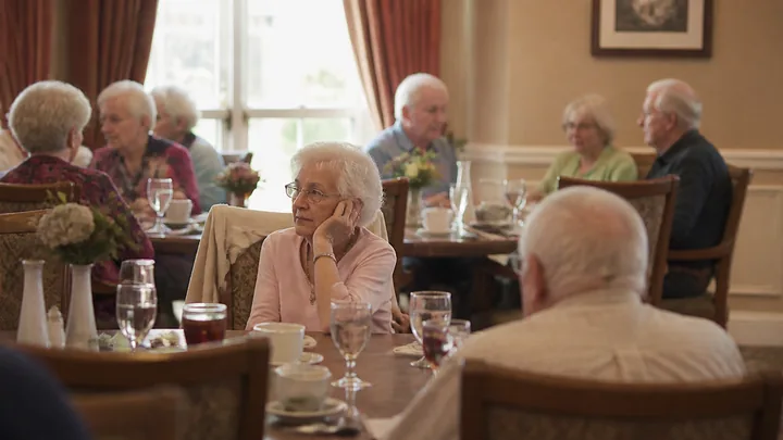 An empty table with mismatched chairs, softly blurred in close view