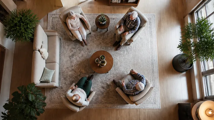Overhead view of four residents seated together around a coffee table